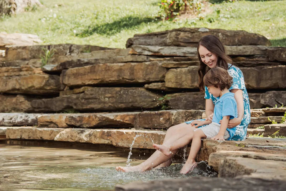 Mom and son dipping their feet in the water at the South Park cascades