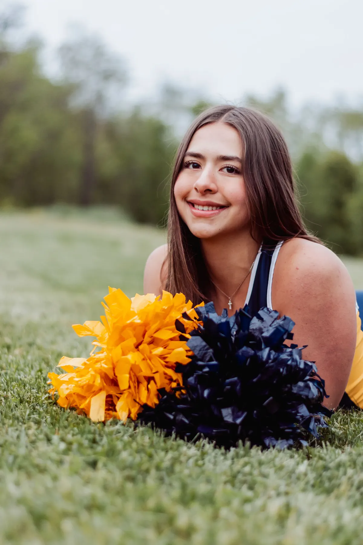 Mt. Lebanon senior smiling beside her blue and gold pom-poms