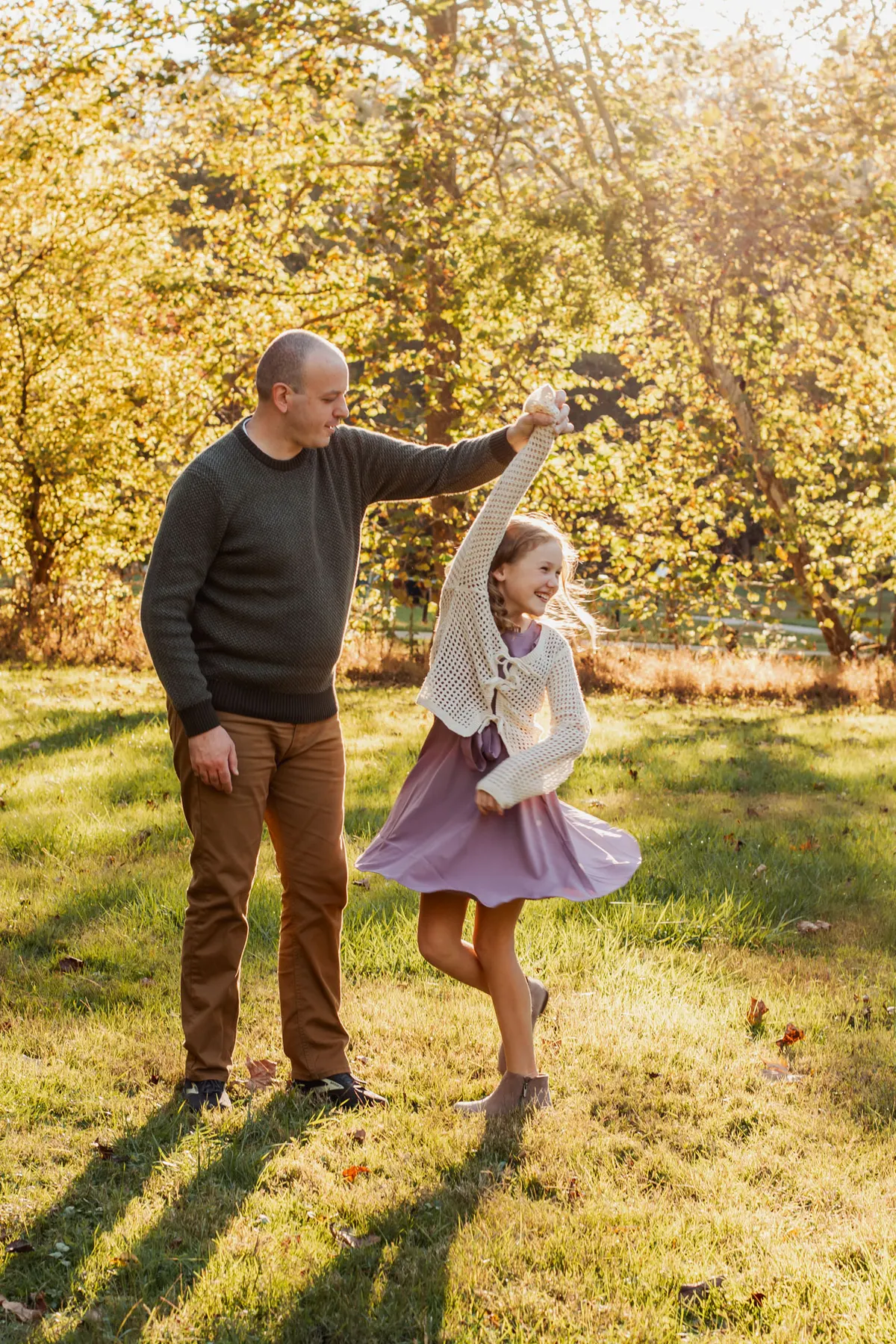 Dad twirling his daughter in evening light