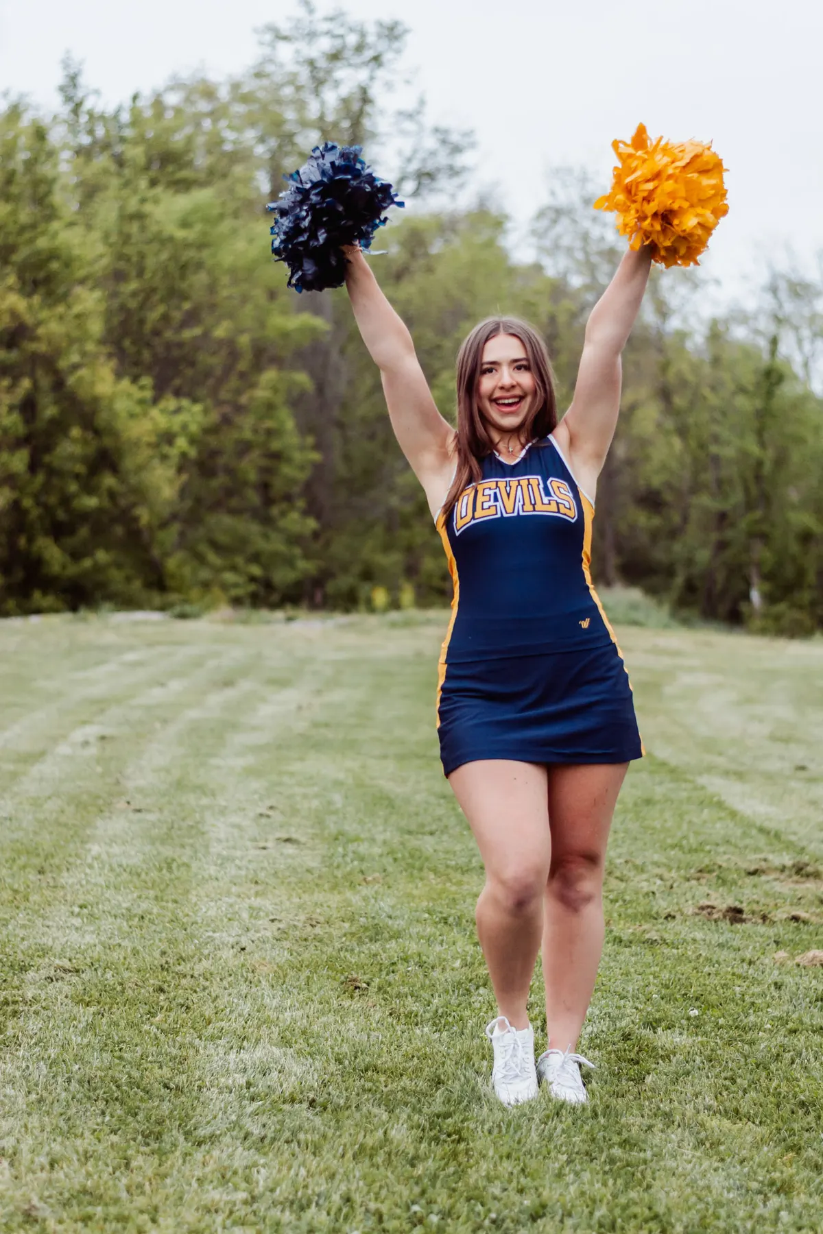 Mt. Lebanon cheerleader raising her pom-poms for her senior portraits