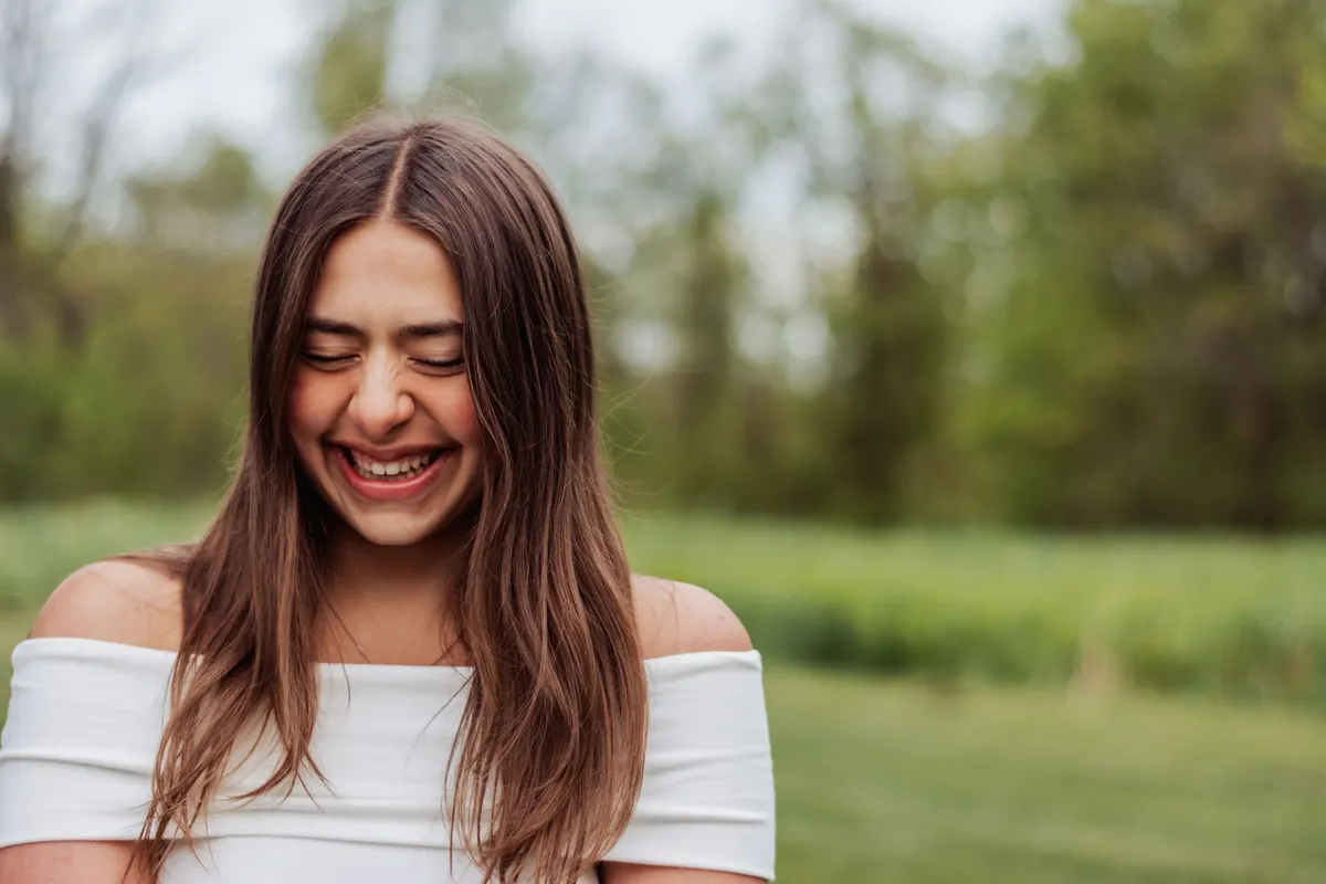 Senior laughing with her eyes closed in soft evening light